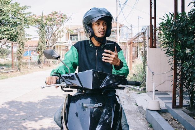 Delivery rider checking an address on his phone